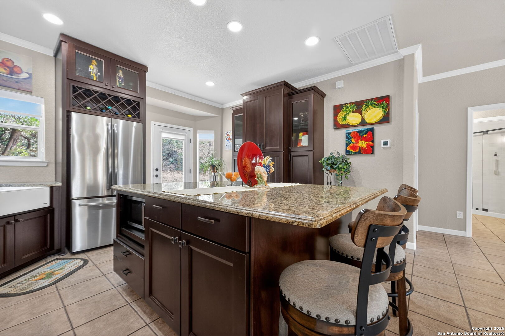 14802 Cross Xd Trail Helotes, TX 78023 - Photo 13 of 58 a kitchen with stainless steel appliances kitchen island granite countertop a table chairs and a refrigerator