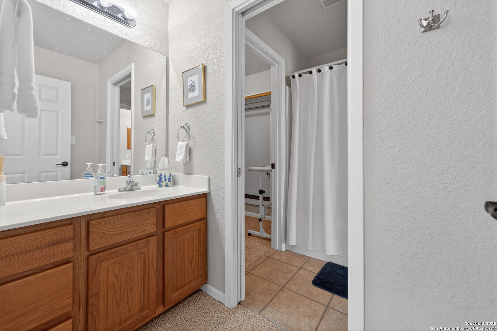 14802 Cross Xd Trail Helotes, TX 78023 - Photo 37 of 58 a bathroom with a double vanity sink a and a mirror
