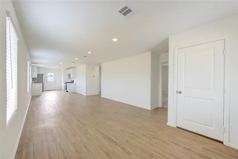 a view of a big room with wooden floor and windows