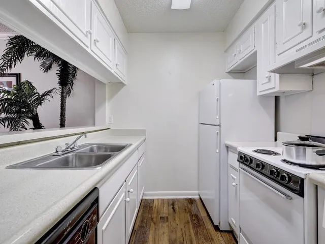 a kitchen with a sink stove and refrigerator