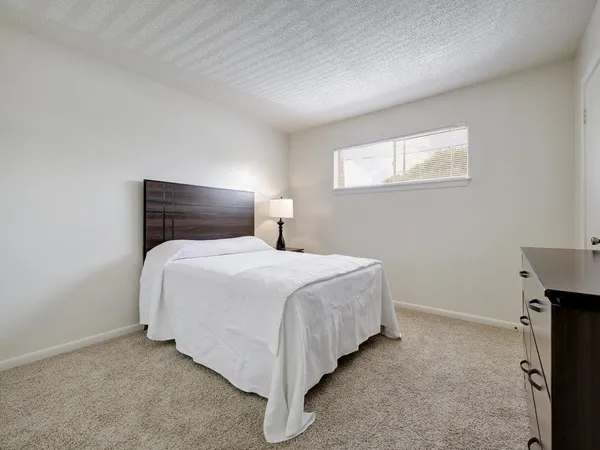 a bedroom with a bed and a window