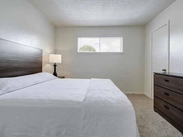 a bedroom with a bed and a night stand