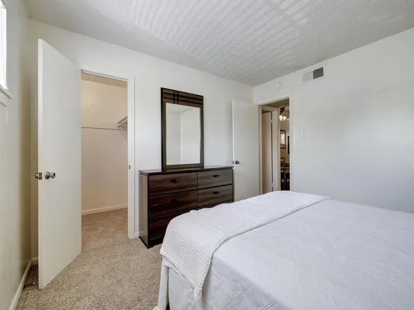 a bedroom with a bed and a mirror