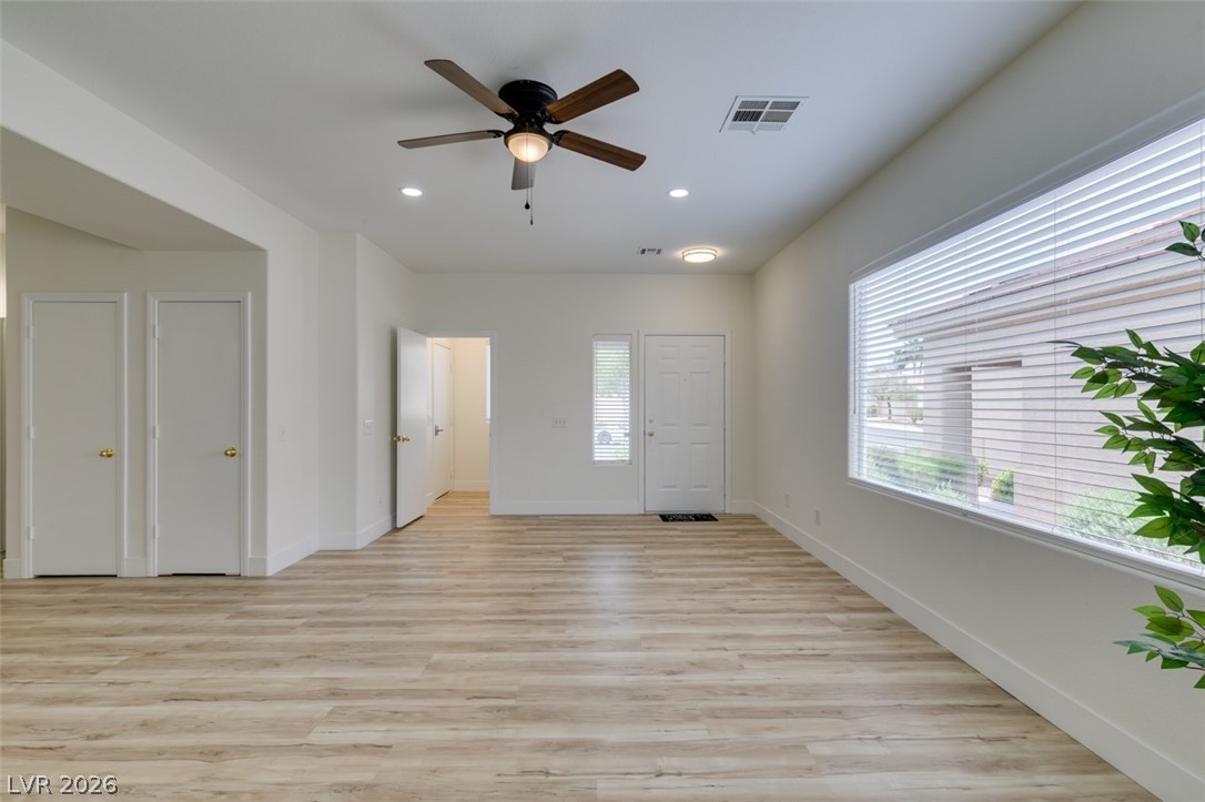 10959 Pumpkin Ridge Avenue Las Vegas, NV 89135 - Photo 3 of 51 A well-lit room showcasing rich LVP flooring and functional ceiling fan.