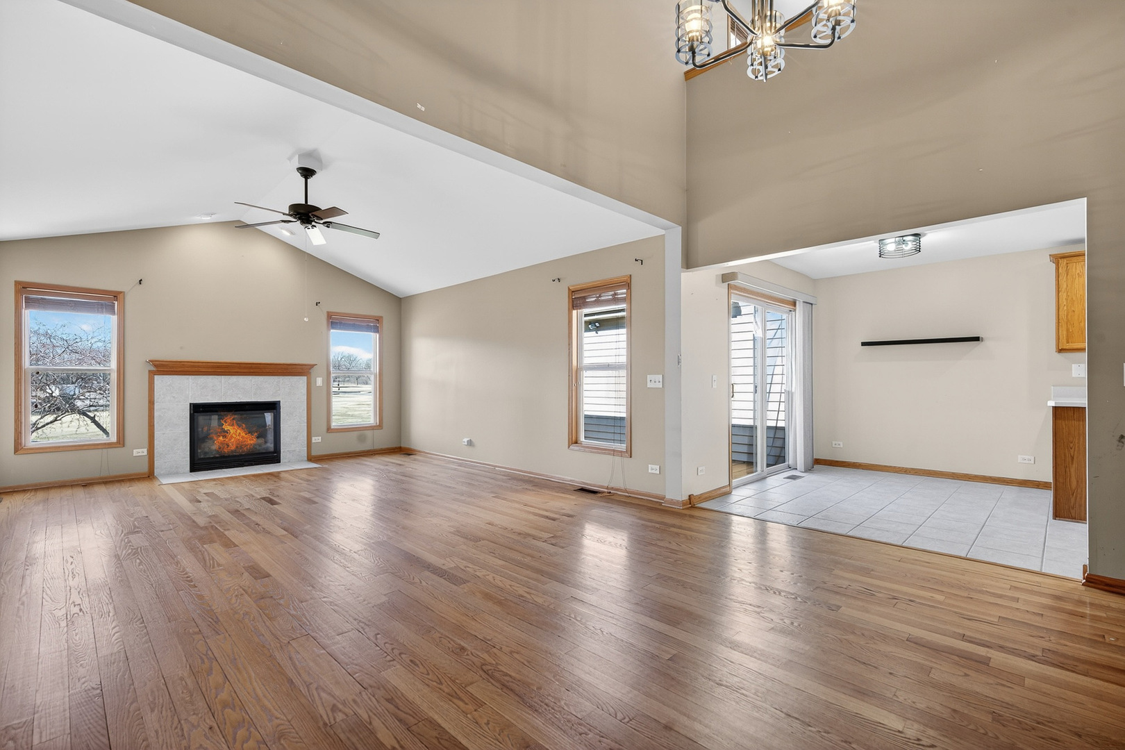 550 Madison Lane Elgin, IL 60123 - Photo 6 of 33 an empty room with wooden floor fireplace and windows