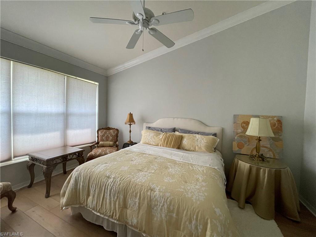 1380 Tiffany Lane, Unit 2204 Naples, FL 34105 - Photo 17 of 29 a bedroom with a bed and a chandelier