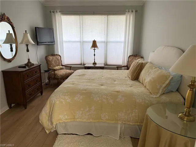 a bedroom with a bed window and mirror