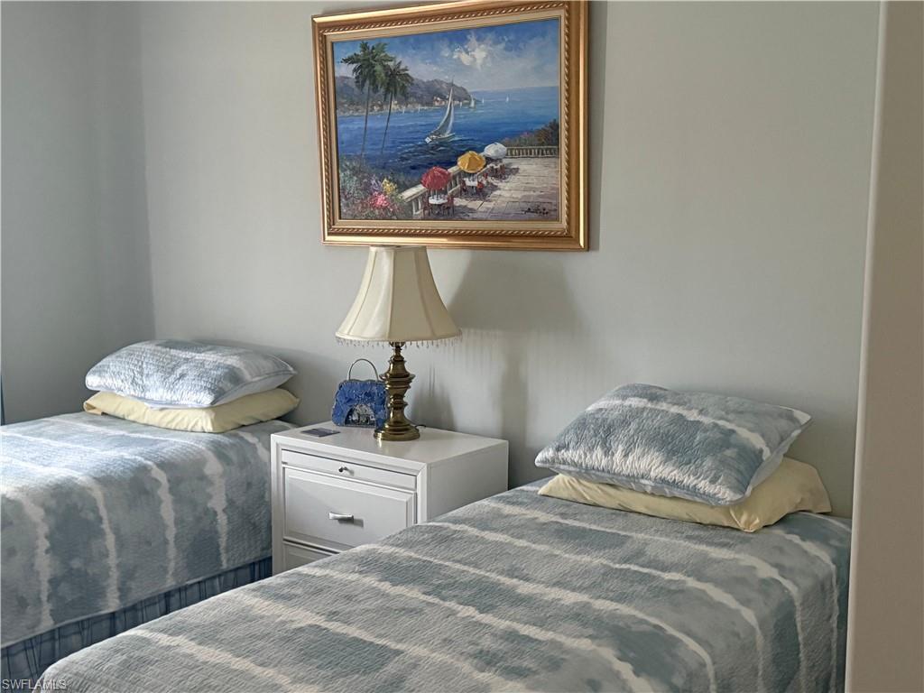 1380 Tiffany Lane, Unit 2204 Naples, FL 34105 - Photo 20 of 29 a bedroom with a bed and a painting on the wall
