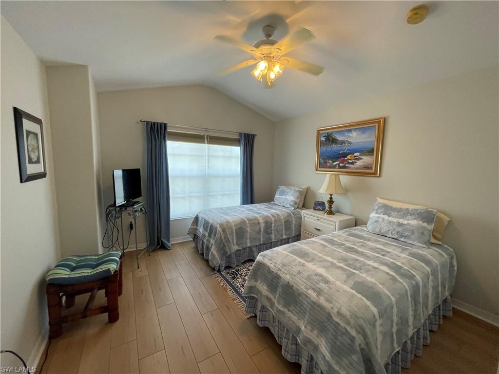 1380 Tiffany Lane, Unit 2204 Naples, FL 34105 - Photo 21 of 29 a bedroom with two beds and a chandelier