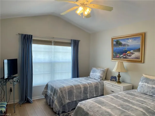 a bedroom with two beds and a flat screen tv