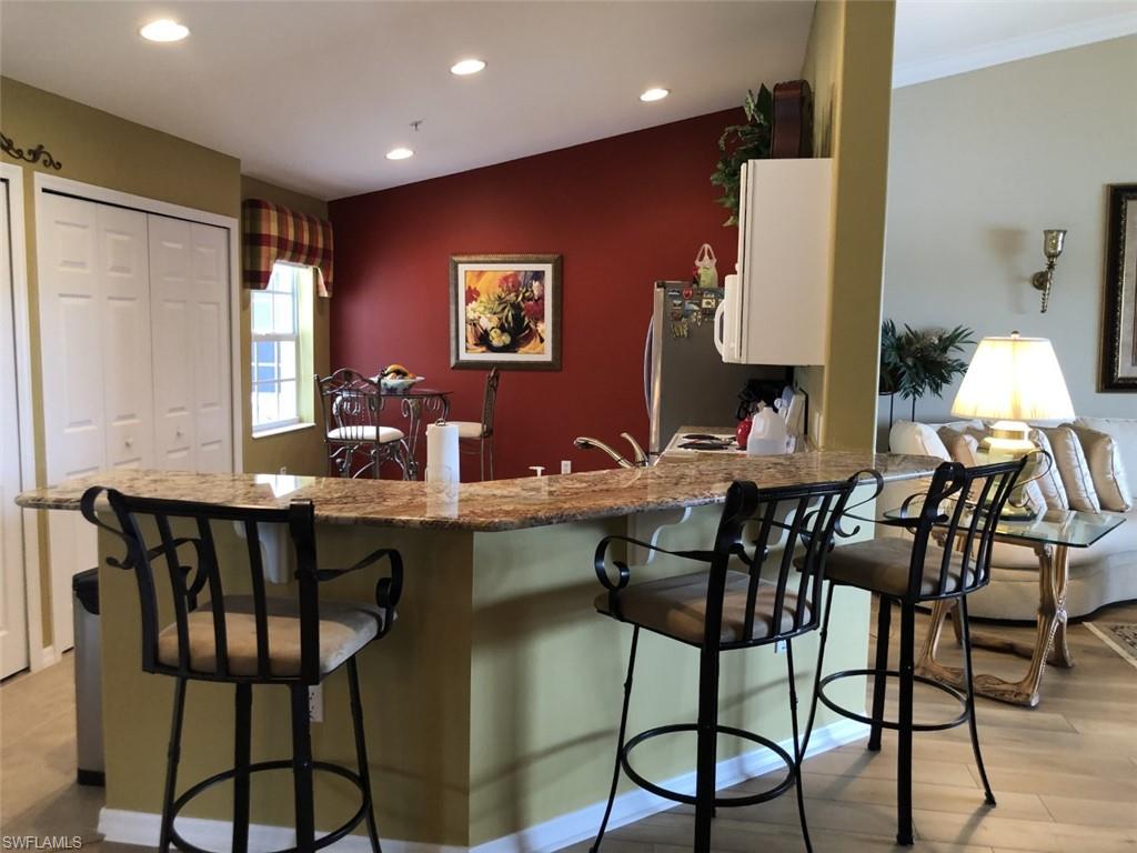 1380 Tiffany Lane, Unit 2204 Naples, FL 34105 - Photo 6 of 29 a view of a dining room with furniture and wooden floor