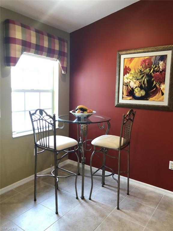 1380 Tiffany Lane, Unit 2204 Naples, FL 34105 - Photo 8 of 29 a view of a dining room with furniture a rug and a window