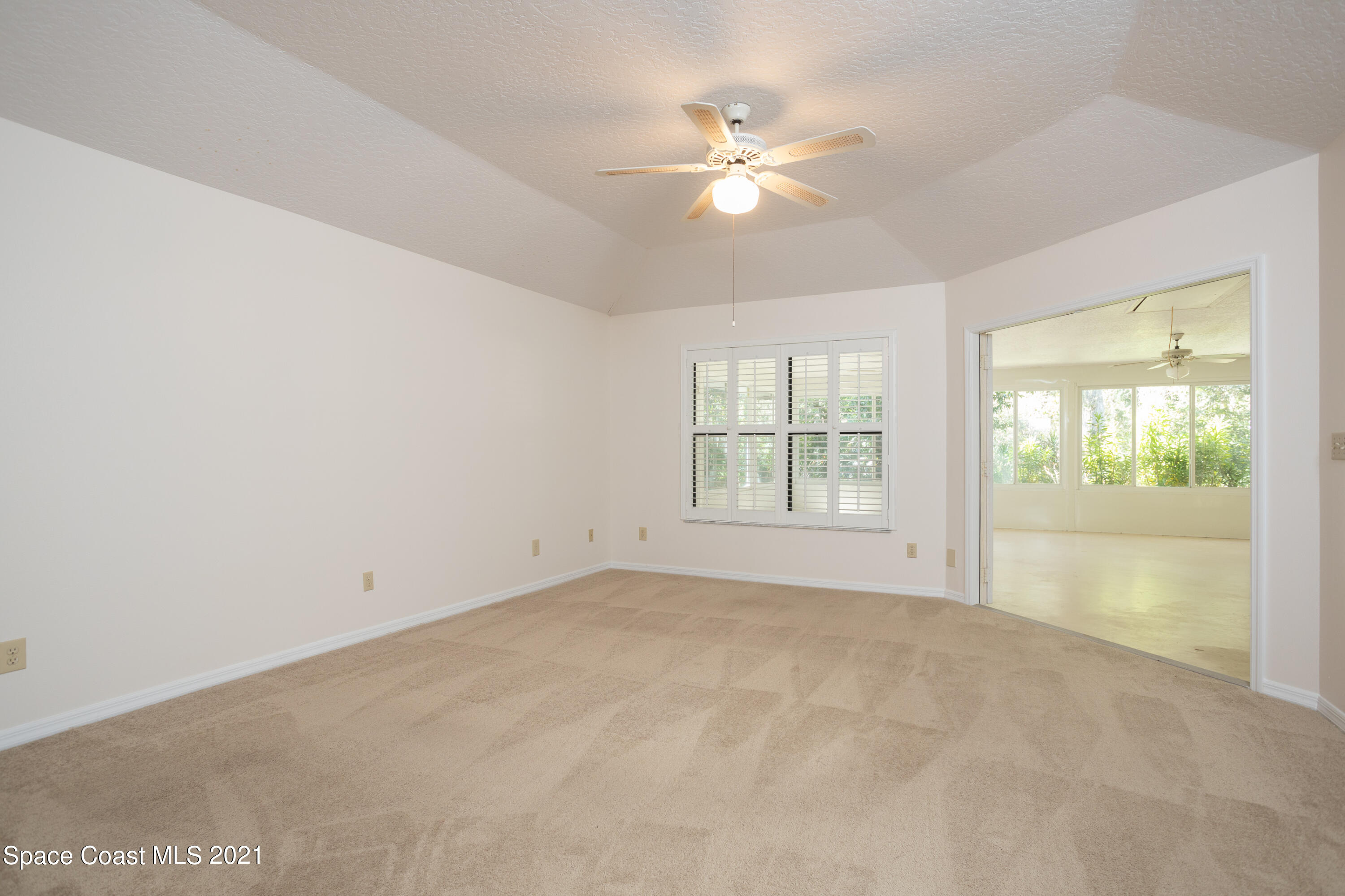 3930 Hammock Road Mims, FL 32754 - Photo 12 of 28 en empty room with windows and chandelier fan