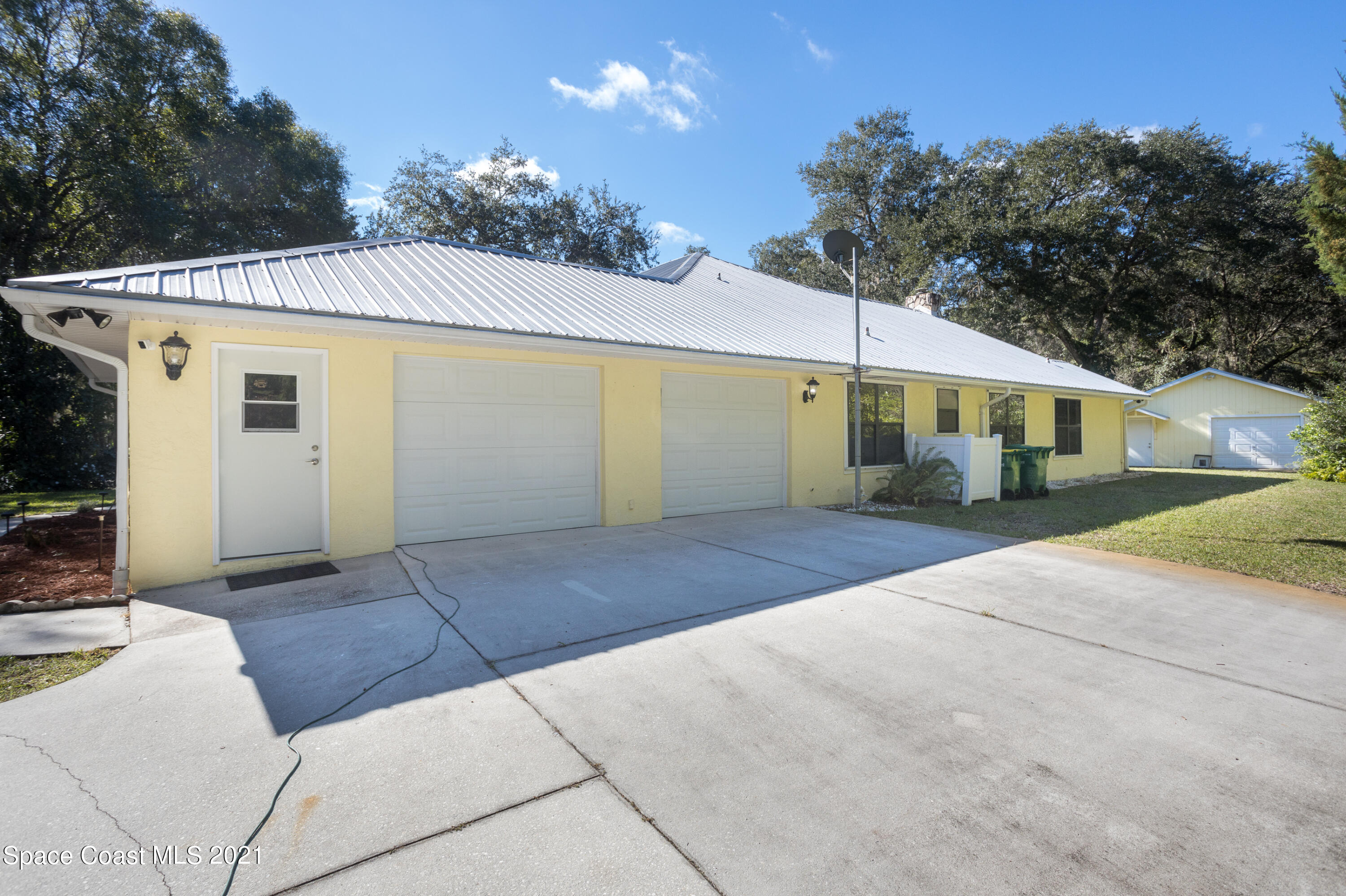 3930 Hammock Road Mims, FL 32754 - Photo 23 of 28 a front view of a house with a yard and garage