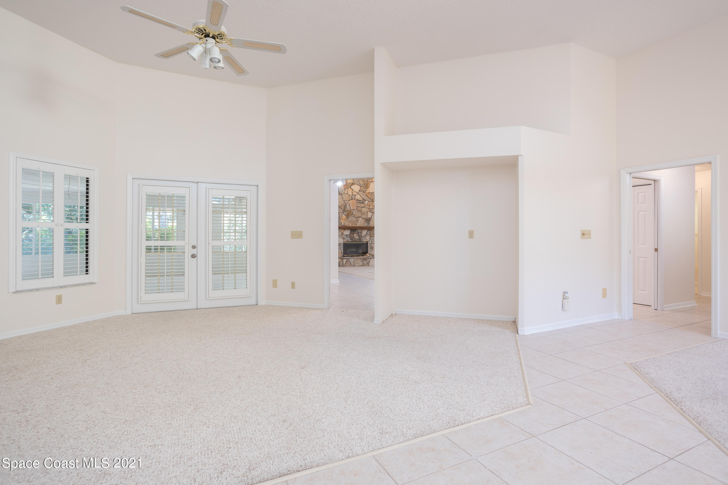 3930 Hammock Road Mims, FL 32754 - Photo 4 of 28 an empty room with chandelier fan and windows