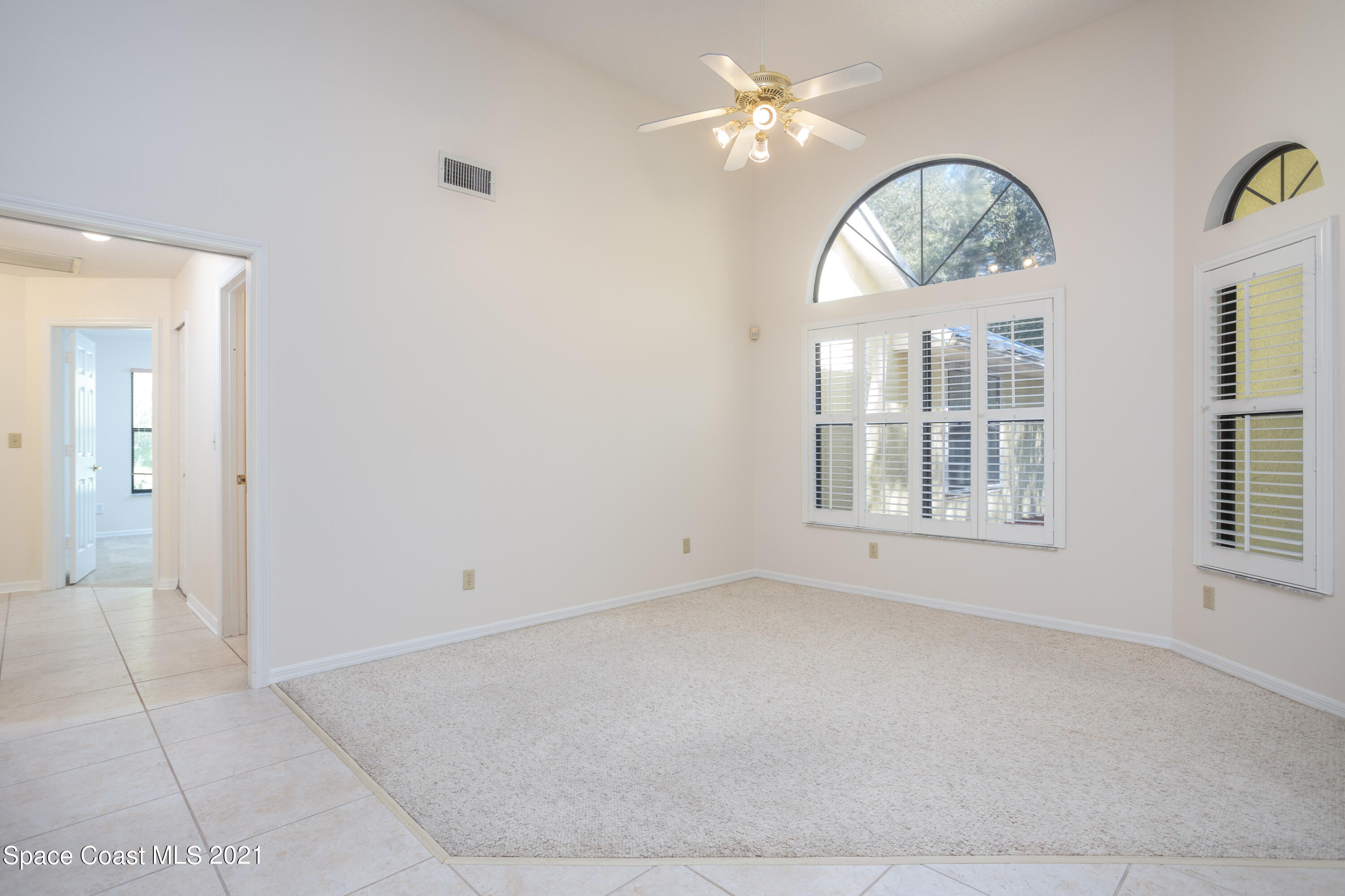 3930 Hammock Road Mims, FL 32754 - Photo 5 of 28 an empty room with chandelier fan and windows