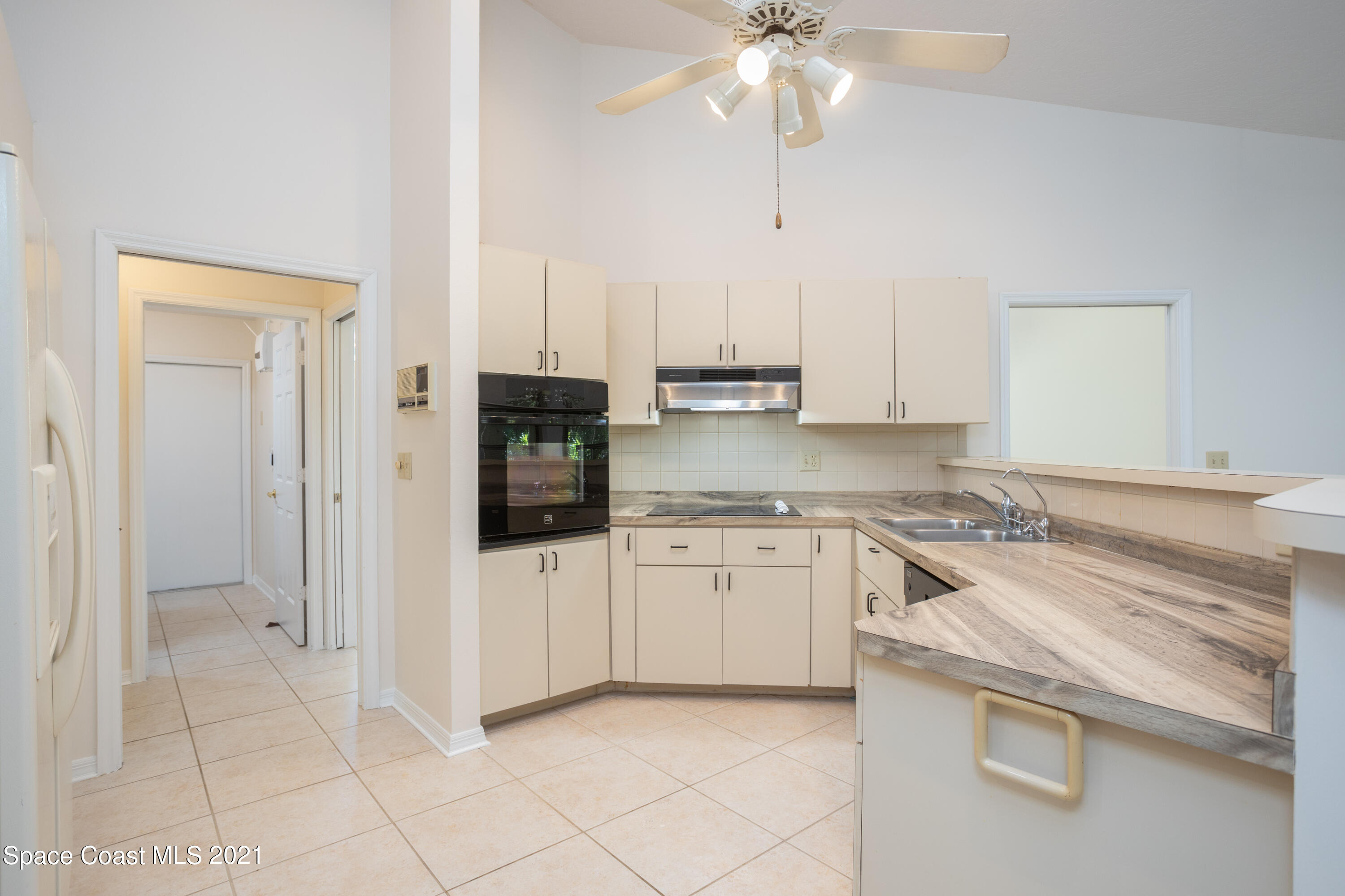 3930 Hammock Road Mims, FL 32754 - Photo 9 of 28 a kitchen with granite countertop white cabinets and white appliances