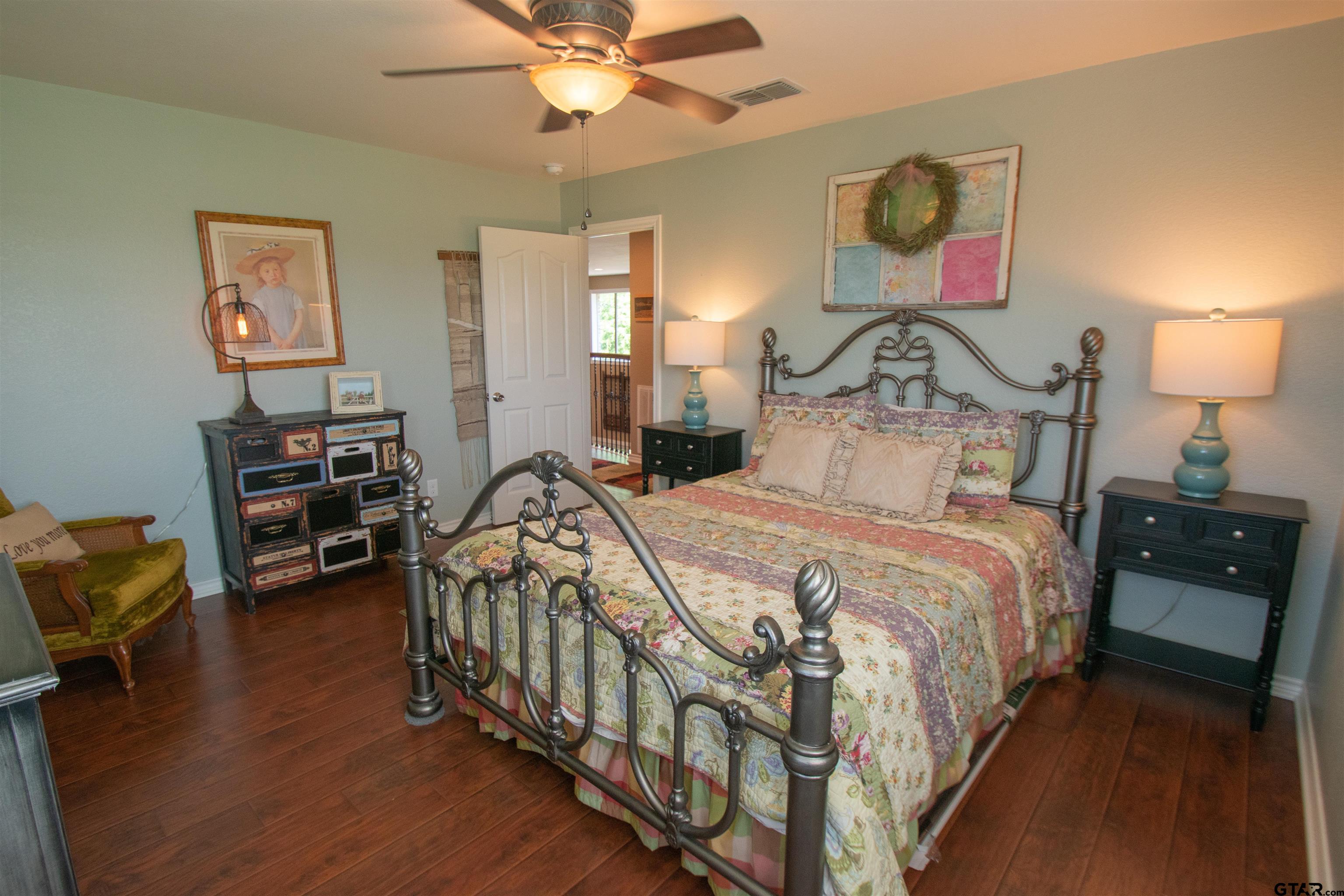 23120 Saddle Ridge Court Lindale, TX 75771 - Photo 22 of 34 a bedroom with bed and a chandelier