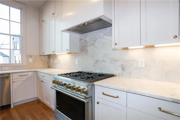 a kitchen with white cabinets and appliances