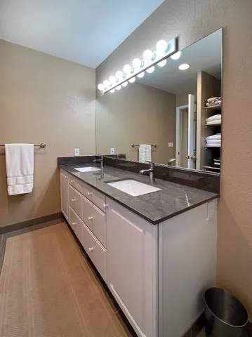 a bathroom with a granite countertop sink a large mirror and vanity