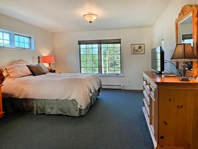 a bedroom with a bed next to a window