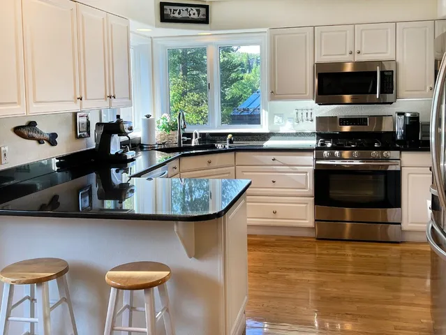 a kitchen with stainless steel appliances a stove a sink and a microwave