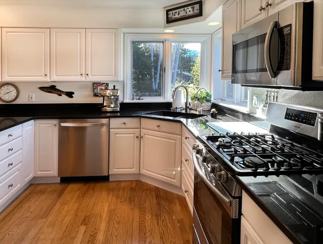 a kitchen with stainless steel appliances a stove a sink and a microwave