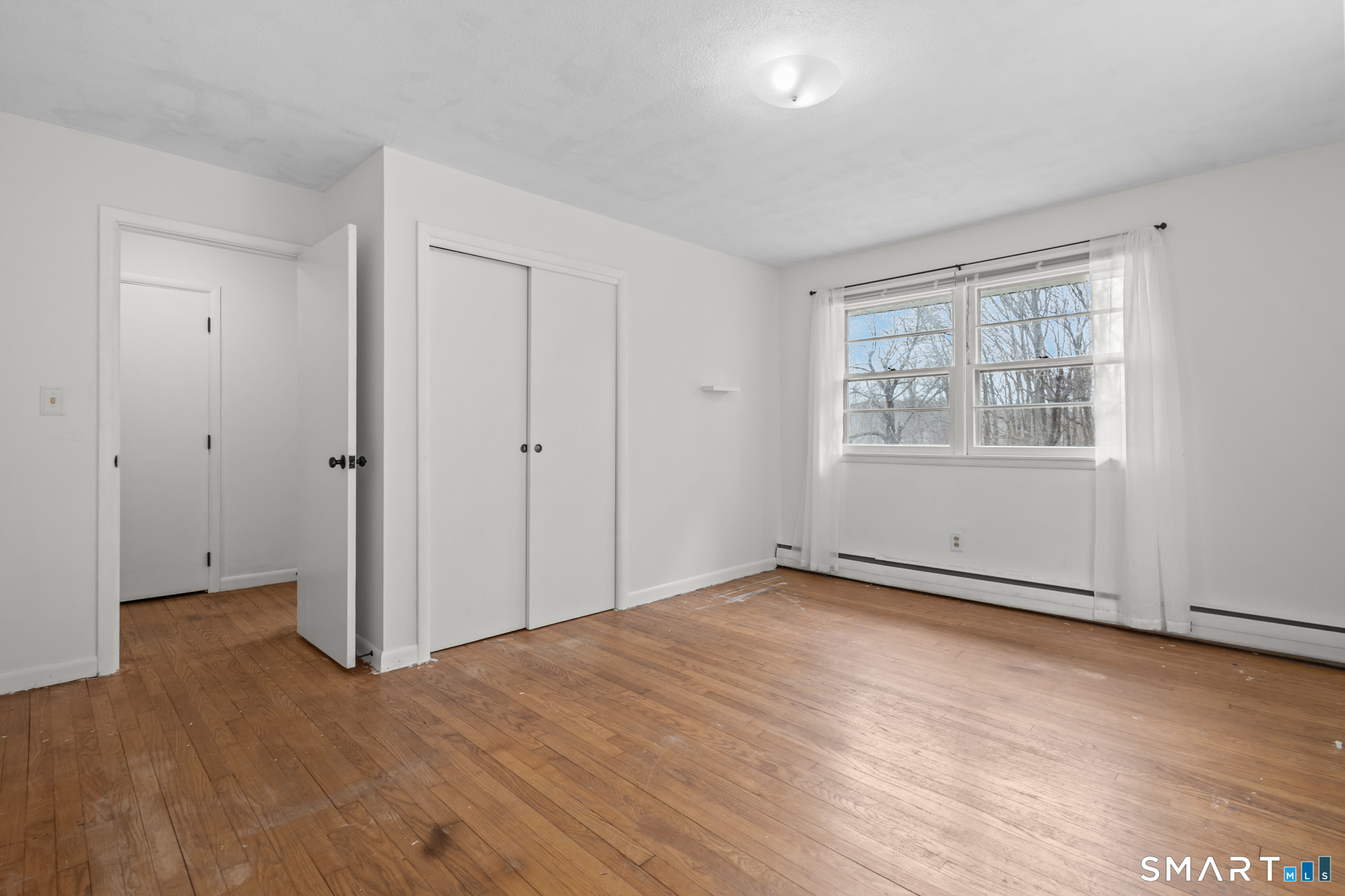 226 Beaumont Highway Lebanon, CT 06249 - Photo 32 of 43 a view of an empty room with wooden floor and a window