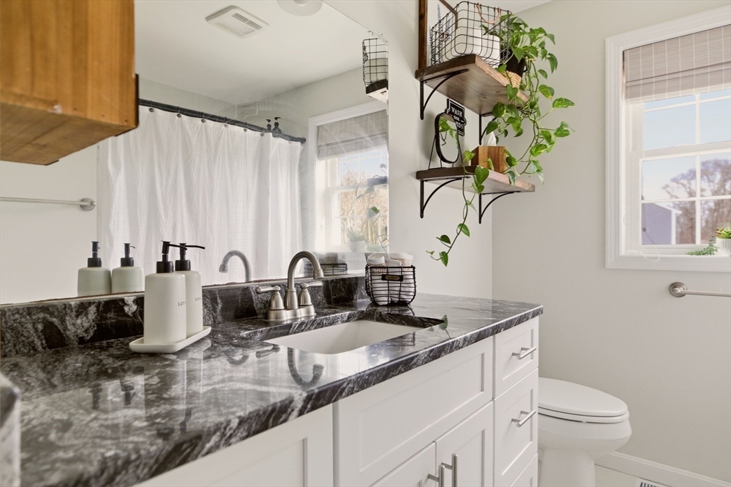 341 Courtney Street Fall River, MA 02720 - Photo 23 of 39 a bathroom with a granite countertop sink a toilet and mirror