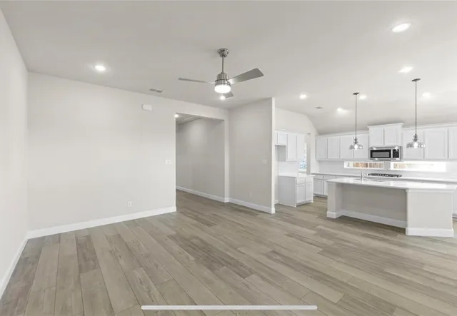 a view of kitchen with granite countertop cabinets and refrigerator