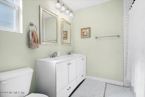 a bathroom with a toilet sink and mirror