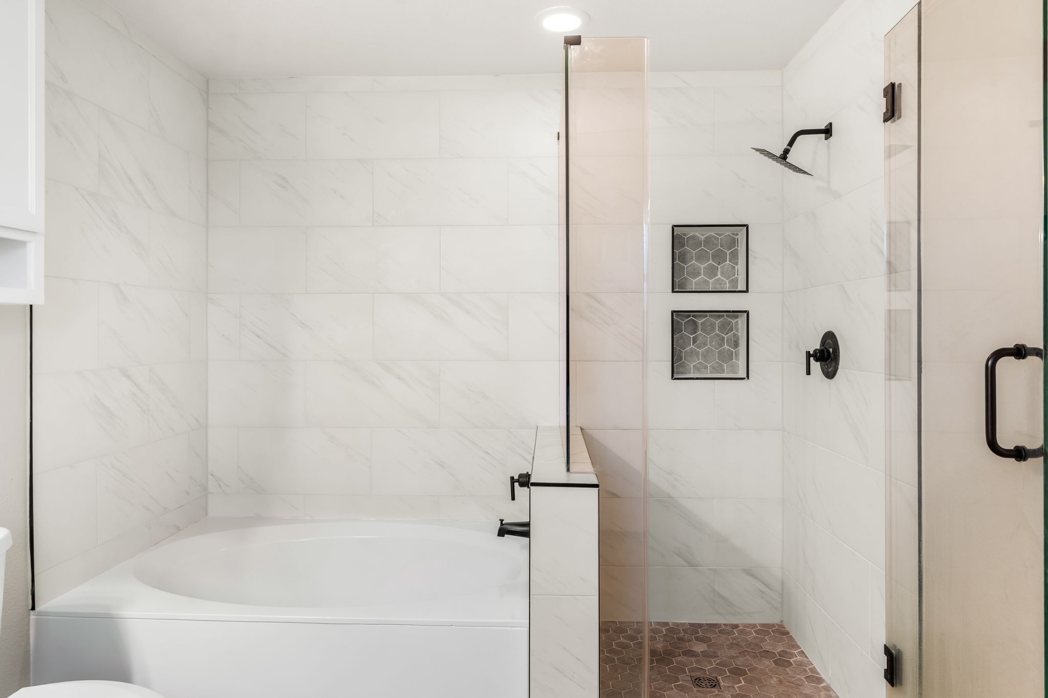 1133 Yellow Iris Road Leander, TX 78641 - Photo 25 of 37 Bathtub and shower combination featuring white tiled walls, matte black fixtures, and a glass shower enclosure