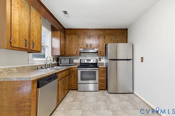 a kitchen with granite countertop a refrigerator stove and oven