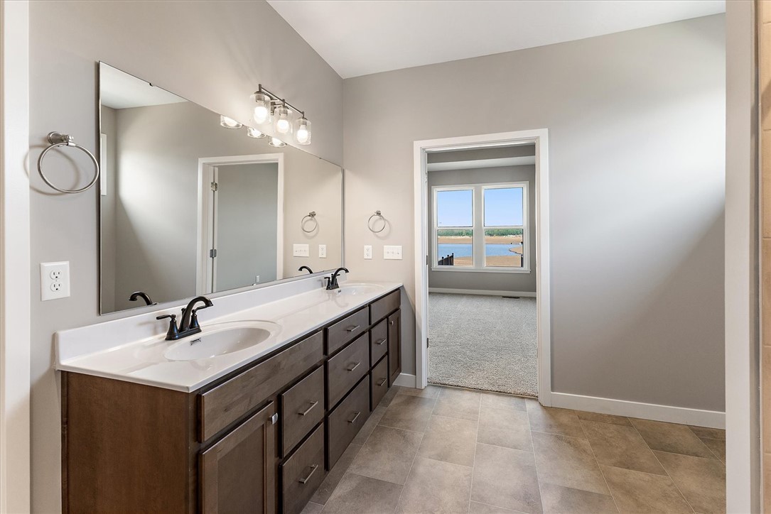 407 South Landon Lane Springfield, OH 45502 - Photo 12 of 30 This spacious bathroom offers a double vanity and seamless access to a room with serene water views.