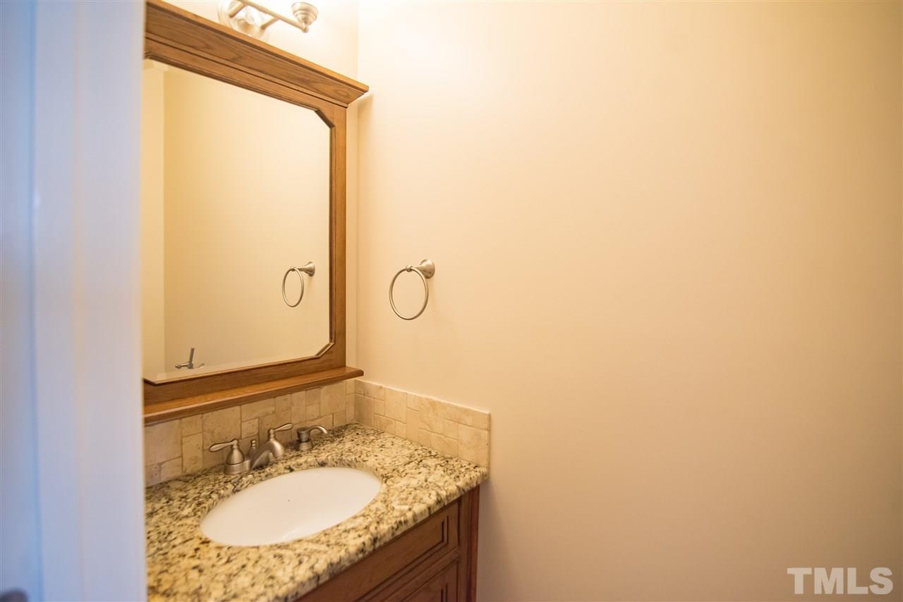 5525 Keowee Way Raleigh, NC 27616 - Photo 14 of 23 The powder room features vanity sink with cabinet storage, mirror and sconce lighting.