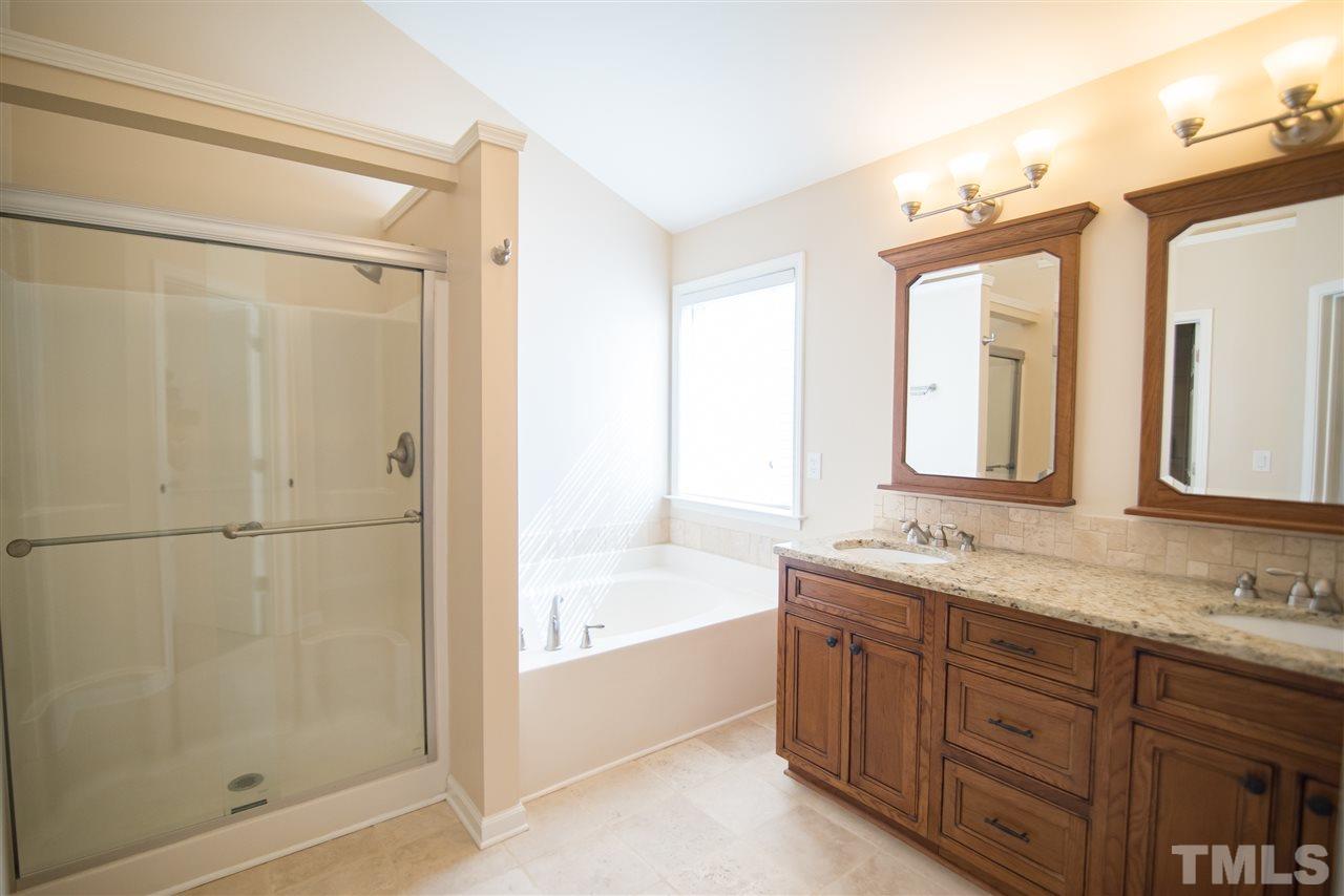 5525 Keowee Way Raleigh, NC 27616 - Photo 16 of 23 The spa-like master bathroom features his and hers sinks, walk-in shower and soaking tub.