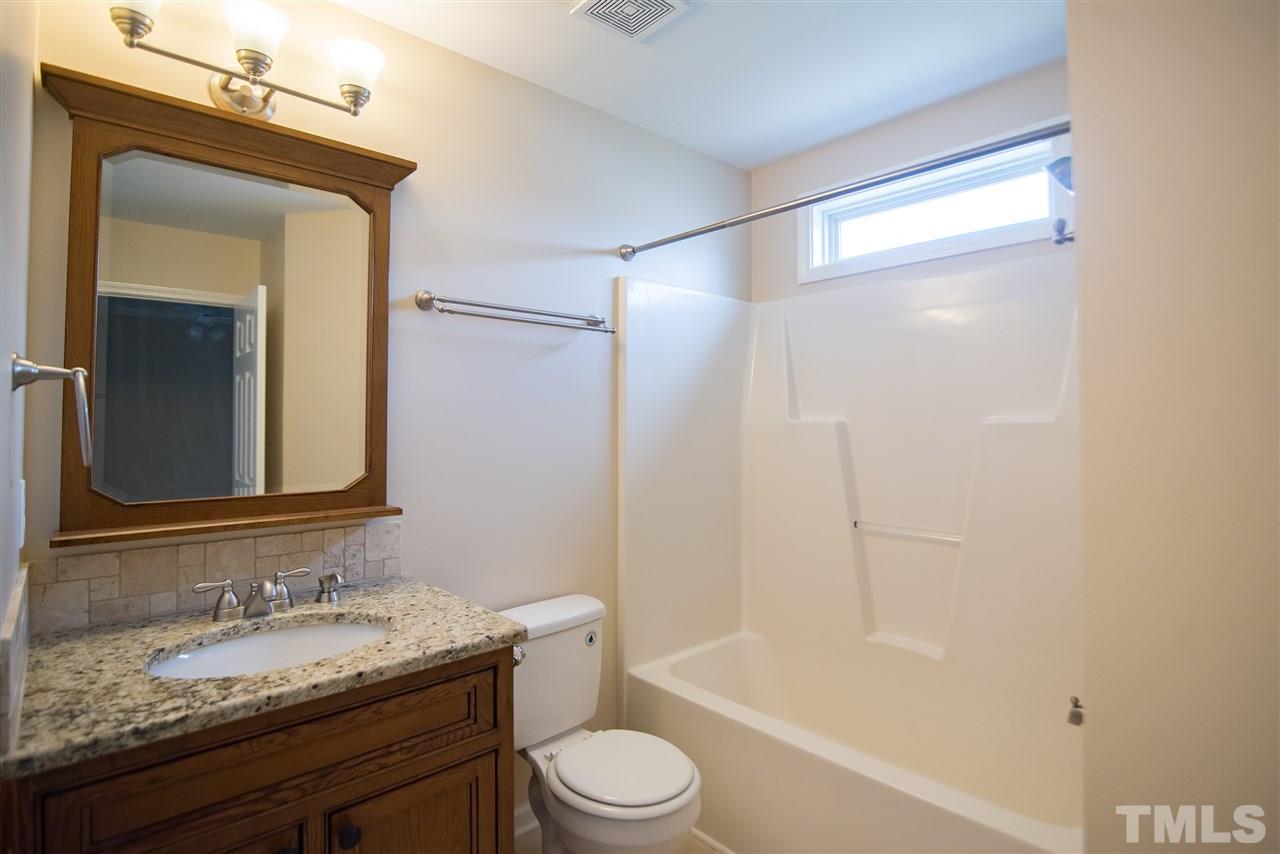 5525 Keowee Way Raleigh, NC 27616 - Photo 19 of 23 The hall bathroom features single vanity sink, sconce lighting and practical tub/shower combo.