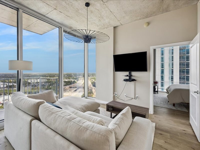 5925 Almeda Road, Unit 12202 Houston, TX 77004 - Photo 9 of 33 Enjoy an open layout with expansive windows that fill the home with natural light. The living area flows effortlessly into the secondary suite, creating an airy, loft-inspired design with spectacular city views.