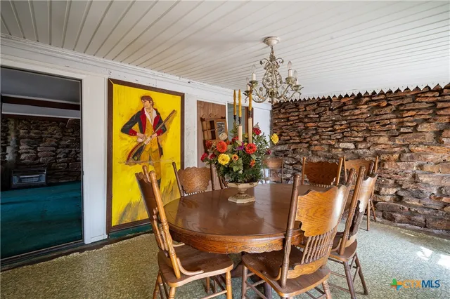 a view of a dining room with furniture and chandelier
