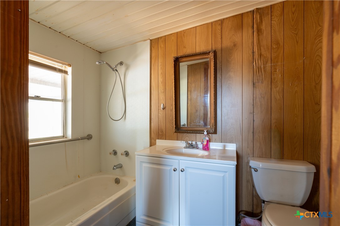 3779 Mule Creek Road Harwood, TX 78632 - Photo 18 of 40 a bathroom with a granite countertop toilet sink and mirror