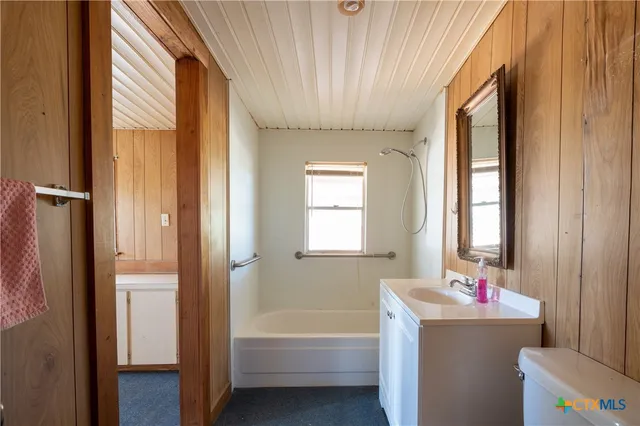 a bathroom with a bathtub a sink and a window
