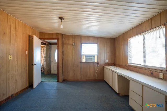 a view of an empty room with window and bathroom