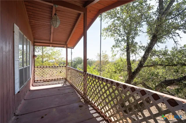 a view of balcony with wooden floor and fence
