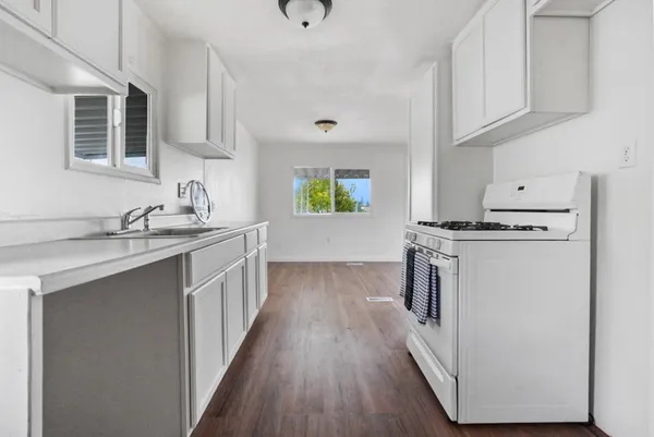 a kitchen with kitchen island granite countertop a sink and wooden cabinets