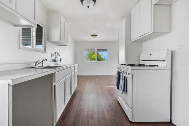 a kitchen with kitchen island granite countertop a sink and wooden cabinets