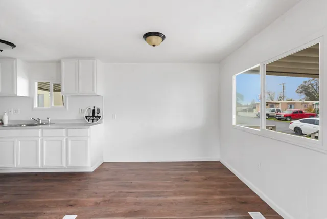 a kitchen with granite countertop a sink cabinets and wooden floor