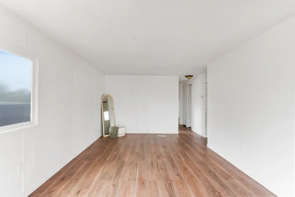 a view of empty room with wooden floor