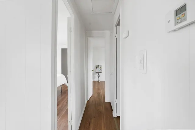 a view of a hallway with wooden floor