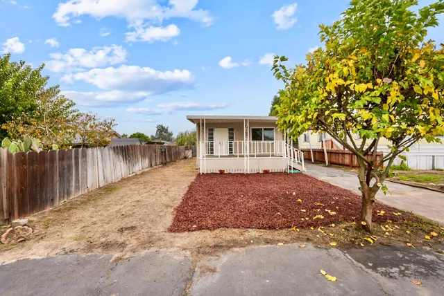 a front view of house with yard and trees