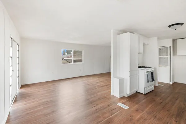 a view of a kitchen with wooden floor and a sink